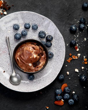 Chocolate ice cream with berries on dark background. Top view