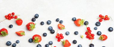 Various fresh berries on neutral background. Organic valuable food source. Top view, copy space, panorama