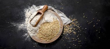 Raw green buckwheat on dark background. Food ingredients. Concept of organic food. Top view, copy space, panorama