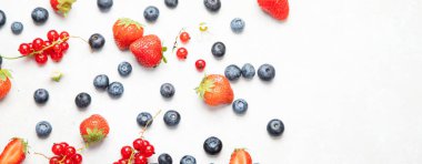 Various fresh berries on neutral background. Organic valuable food source. Top view, copy space, panorama
