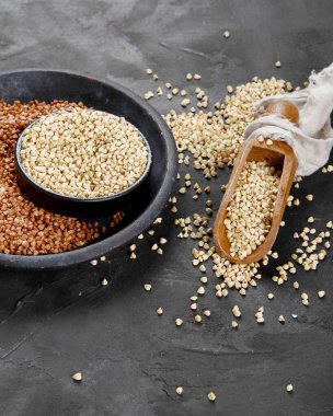 Raw green buckwheat on dark background. Food ingredients. Concept of organic food.