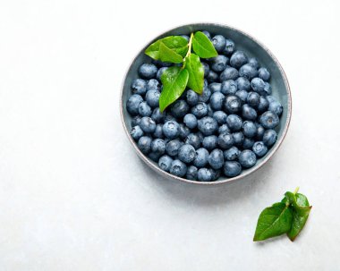 Fresh blueberry on neutral background. Vegan and vegetarian concept. Top view, copy space