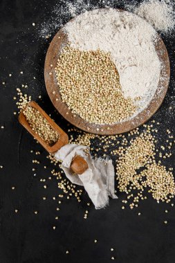 Raw green buckwheat on dark background. Food ingredients. Concept of organic food. Top view, copy space