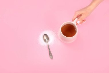 Cup of tea with sugar substitute on pink background. Healthy hot beverage. Top view, flat lay, copy space