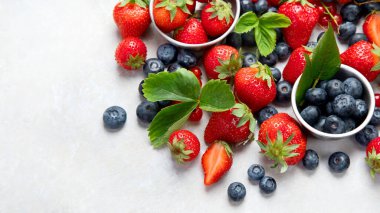 Various fresh berries on neutral background. Organic valuable food source. Top view, copy space