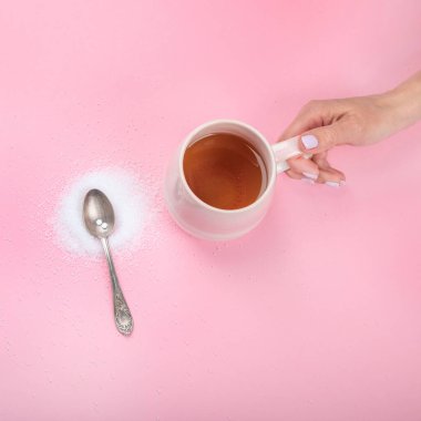 Cup of tea with sugar substitute on pink background. Healthy hot beverage. Top view, flat lay, copy space