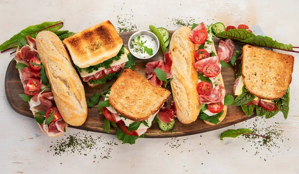 Assorted delicious baguette sandwiches. Various kinds of club sandwiches on a white background. Top view.