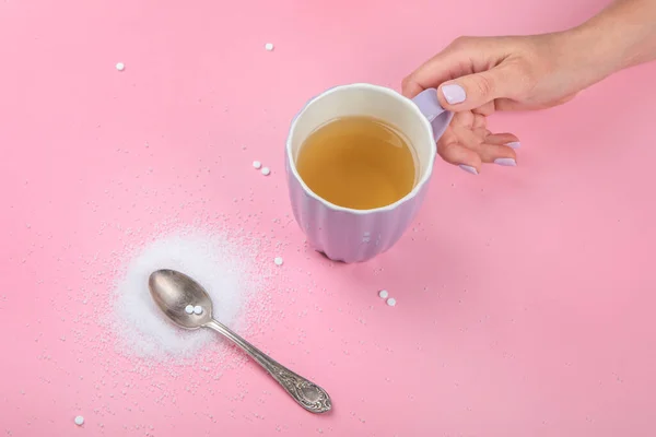 Cup of tea with sugar substitute on pink background. Healthy hot beverage. Top view, flat lay, copy space