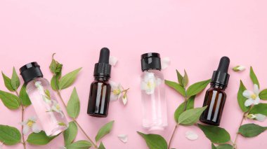 Yasemin çiçekli yağlı şişeler. Vücut ve yüz bakımı için doğal kozmetik ve güzellik ürünleri. Üst görünüm, düz görünüm, kopyalama alanı