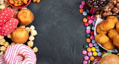 Sağlıksız ürünler. Yemek vücut, deri, kalp ve dişler için kötüdür. Fast karbonhidrat karışımı. Arka planda patates kızartması ve kola var. Kopyalama alanı olan üst görünüm.