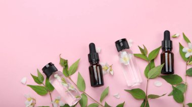 Yasemin çiçekli yağlı şişeler. Vücut ve yüz bakımı için doğal kozmetik ve güzellik ürünleri. Üst görünüm, düz görünüm, kopyalama alanı