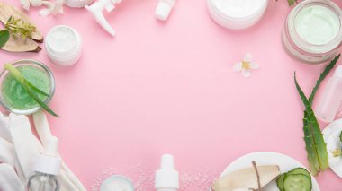Pembe arka planda yüz ve vücut bakım ürünleri. Doğal kozmetikler. Üst görünüm, düz görünüm, kopyalama alanı