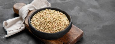 Raw green buckwheat on dark background. Food ingredients. Concept of organic food. panorama, copy space