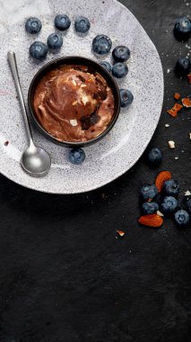 Chocolate ice cream with berries on dark background. Top view, copy space