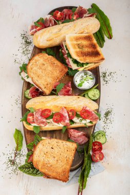 Assorted delicious baguette sandwiches. Various kinds of club sandwiches on a white background. Top view.