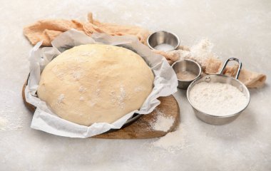 Raw dough pastry in a bowl on neutral background. Homemade bio food concept.