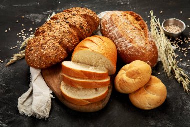 Bread assortment on dark background. Fresh homemade pastry. 