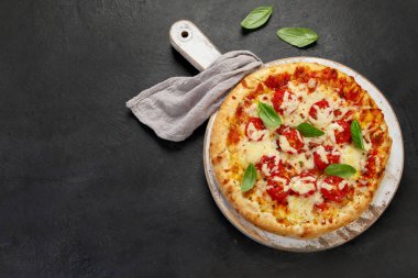 Freshly baked pizza on dark background. Tasty homemade food concept. Top view, copy space