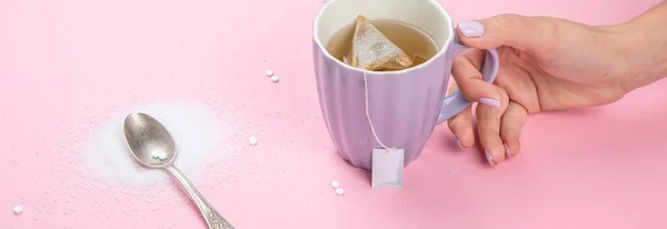 Cup of tea with sugar substitute on pink background. Healthy hot beverage. panoramma, copy space