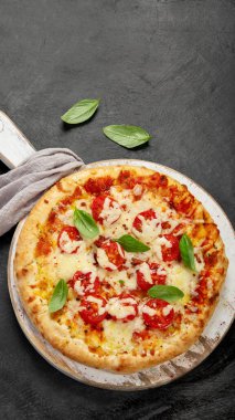 Freshly baked pizza on dark background. Tasty homemade food concept. Top view, copy space