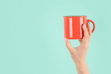 Yeşil arka planda çay fincanı tutan kollar havada. Kavramsal fotoğraf. Ön görünüm, boşluğu kopyala