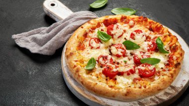 Freshly baked pizza on dark background. Tasty homemade food concept.