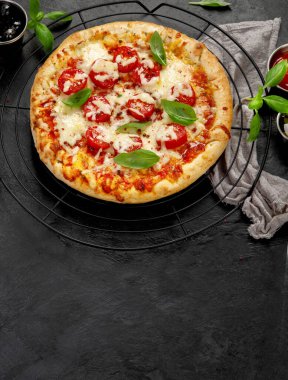 Freshly baked pizza on dark background. Tasty homemade food concept. Top view, copy space