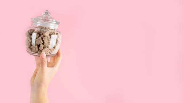 Руки подняты, держа чашку кофе на розовом фоне. Концепция фото. Вид спереди