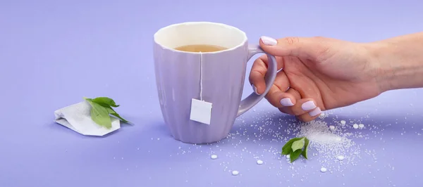 Hand Mit Einer Tasse Tee Künstlicher Zucker Auf Violettem Hintergrund — Stockfoto