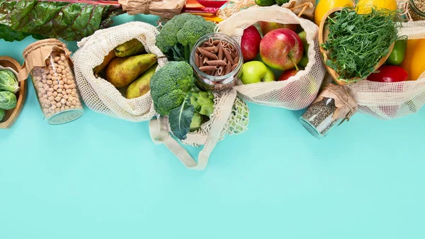 Various organic fruits and vegetables in reusable packaging bags.  Eco friendly  lifestyle concept. Plastic free items. Reuse, reduce, refuse. Top view with copy space