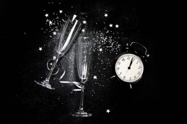 İki şampanya bardağı. Siyah bir arka planda Noel süslemesi. Mutlu yeni yıl kutlamaları. Üst görünüm.