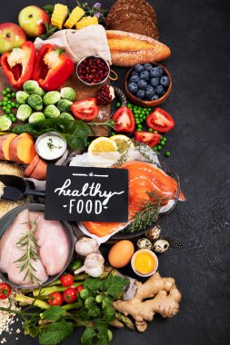 Karanlık arka planda sağlıklı yiyecek seçimi. Detoks ve temiz diyet konsepti. Yüksek miktarda vitamin, mineral ve antioksidan içeren yiyecekler. Yaş karşıtı yiyecekler. Üst görünüm.