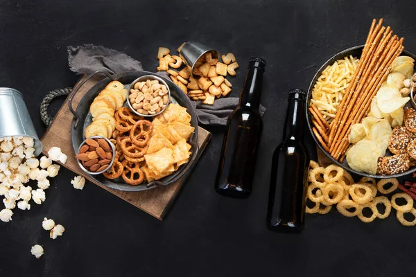 在黑暗背景下分发啤酒和咸味小吃 派对食物的概念 顶部视图 复制空间 — 图库照片