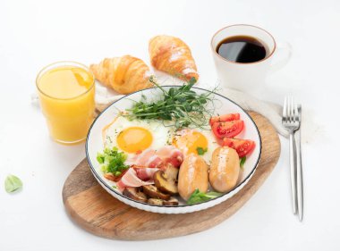 İngiliz kahvaltısı, kızarmış yumurta, sosis, pastırma ve beyaz arka planda tost. 