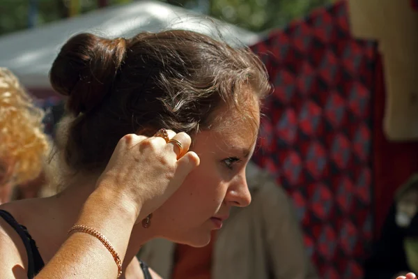 Girl trying on earrings — Stock Photo, Image
