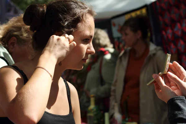 Girl trying on earrings — Stock Photo, Image