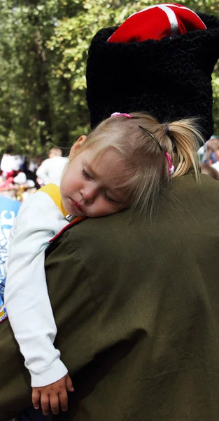 Маленькая девочка спит на плече своего отца, казака — стоковое фото