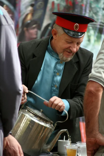 Cossack pours tea from an old kettle — Stock Photo, Image