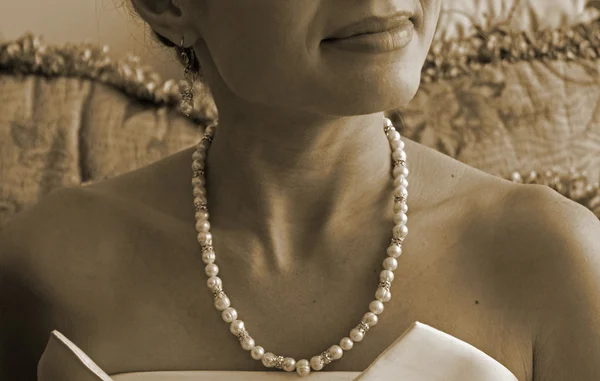 Retro style photo of pearl necklace on the neck of a young woman in an evening dress — Stock Photo, Image