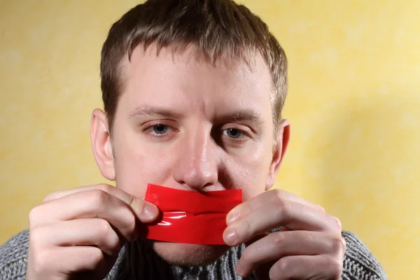 Man closes his mouth red tape — Stock Photo, Image