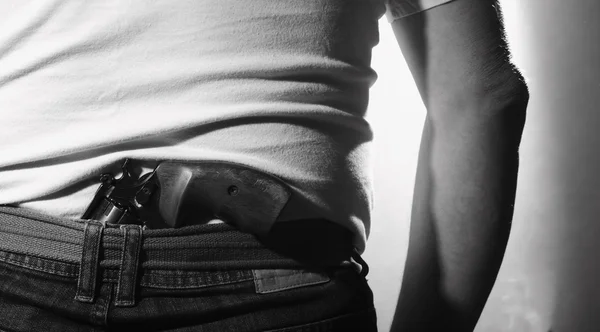 Člověk se schovává zbraň na zádech — Stock fotografie