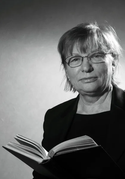 Middle aged woman in eyeglasses with book — Stock Photo, Image