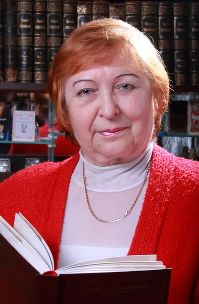 Woman against bookshelf — Stock Photo, Image