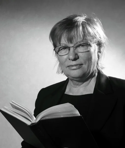 Mellersta äldre kvinna i glasögon med bok — Stockfoto
