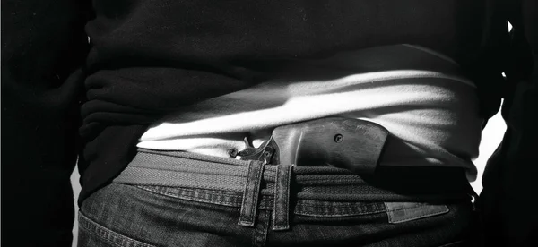 Man is hiding a gun at his back — Stock Photo, Image