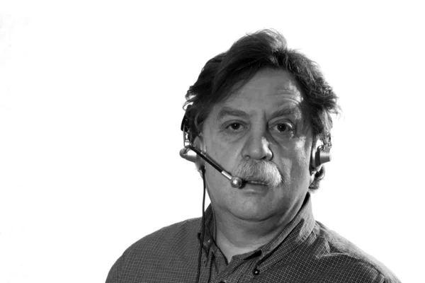 Businessman works in headphones with microphone behind computer — Stock Photo, Image