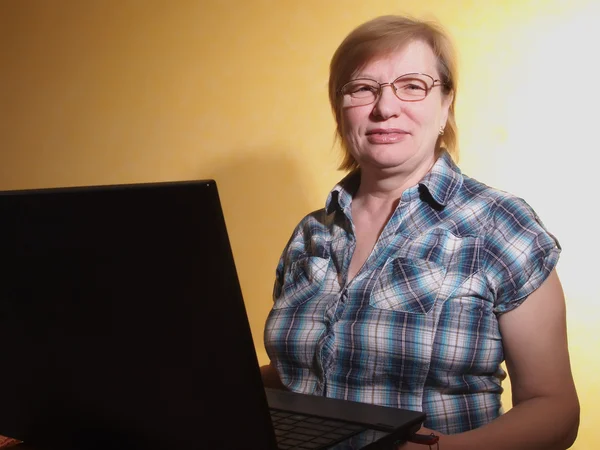 Frau mittleren Alters mit ihrem Laptop — Stockfoto