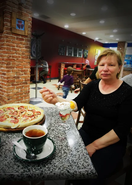 Frau im Café isst Pizza — Stockfoto