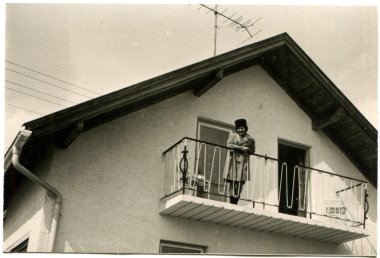 kadın bir yağmurluk ve şapka ayakta balkon