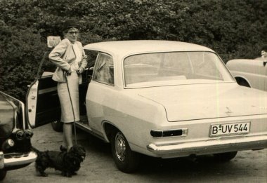 Şık takım elbise ve şapka ile bir köpek tasmalı kadın